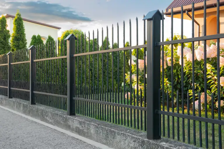 Beautiful black iron fence near pathway outdoors