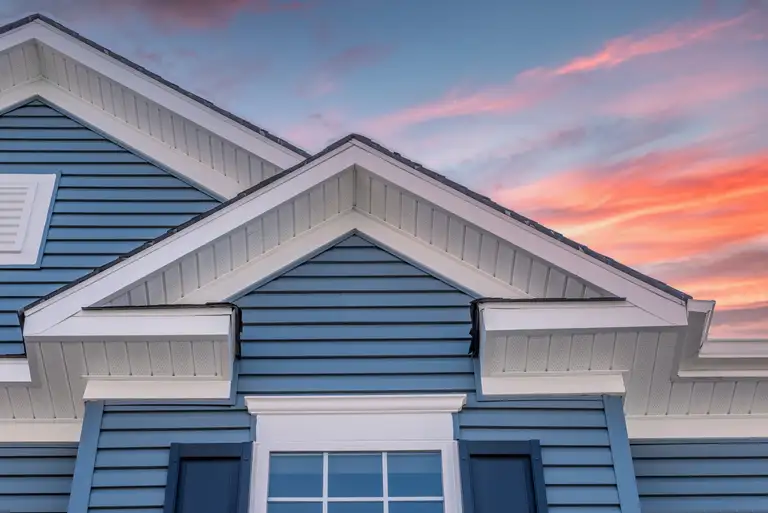 Colonial white soffit and fascia on blue horizontal vinyl siding